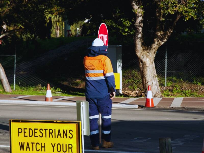 Roadwork zone with traffic controllers ensuring road safety in Australia.